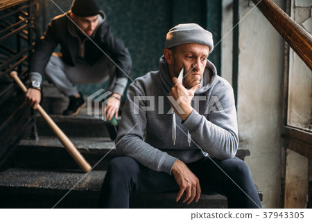 Two male hooligans are sitting on the stairs Two male hooligans are sitting on the stairs 37943305