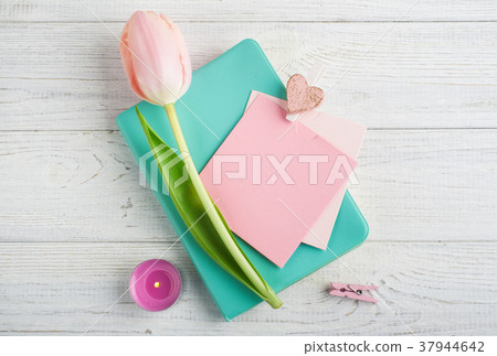 Mint notebook, tulips and lit candle 37944642