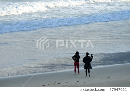 Woman taking a picture on the beach 37947011