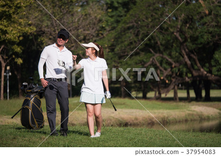 Asian young couple playing golf on golf course 37954083
