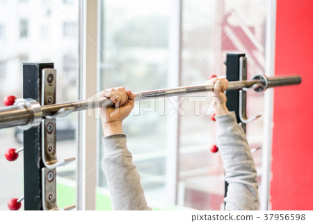 Arms of man working out in the gym, beginner 37956598