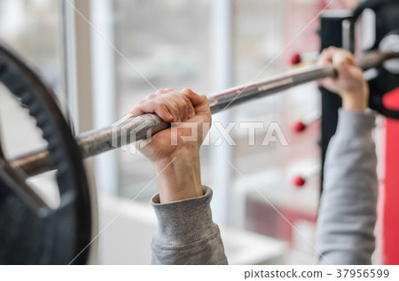 Male arms raising barbell, athlete doing bench 37956599