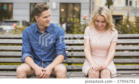 Shy blonde girl smiling, attractive guy flirting 37956791