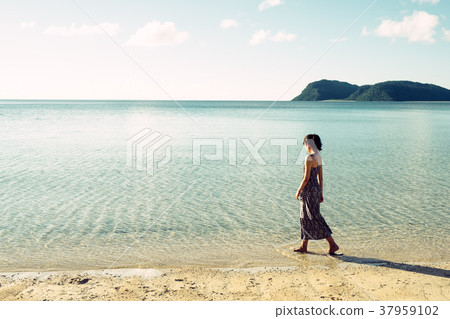 走在一個海灘的婦女在沖繩島 走在一個海灘的婦女在沖繩島 37959102