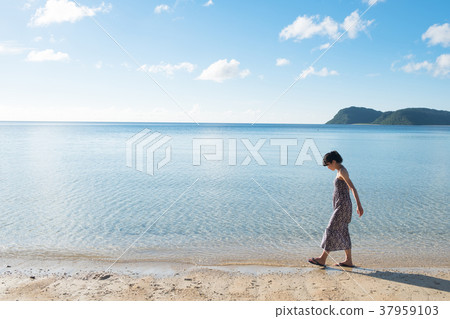 走在一個海灘的婦女在沖繩島 走在一個海灘的婦女在沖繩島 37959103