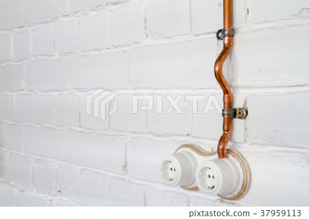 A vintage outlet and electrical wiring in a copper A vintage outlet and electrical wiring in a copper 37959113