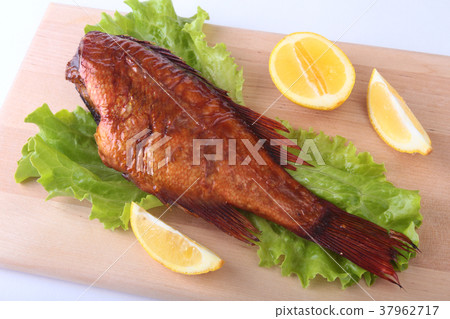 Smoked fish and lemon on green lettuce leave 37962717