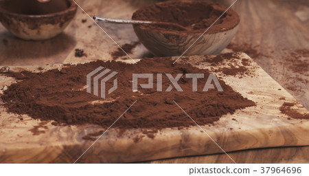 female hands making truffles in cocoa powder on 37964696