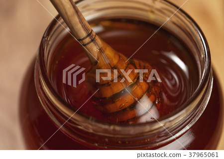 organic honey drips from wooden dipper in jar organic honey drips from wooden dipper in jar 37965061