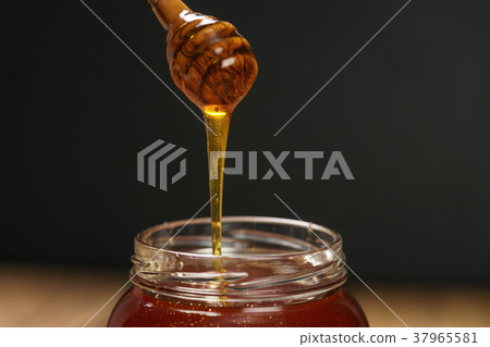organic honey drips from wooden dipper in jar organic honey drips from wooden dipper in jar 37965581