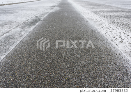 Sidewalk that snow began to pile up 37965883