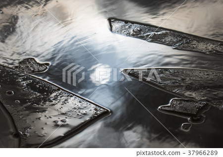 A puddle was broken of frozen ice 37966289