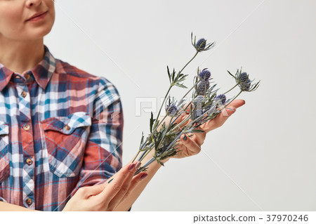Young girl with flowers eryngium 37970246