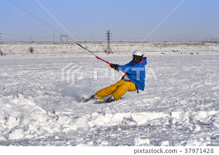 A male athlete engaged in snow kiting  37971428