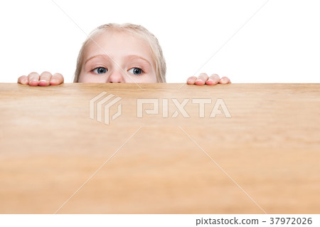Child looks out from under the table Child looks out from under the table 37972026