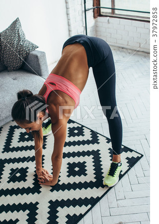 Fitness woman back stretching training at home Fitness woman back stretching training at home 37972858