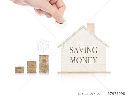 Wooden house model with coins next to it and hand 37972998
