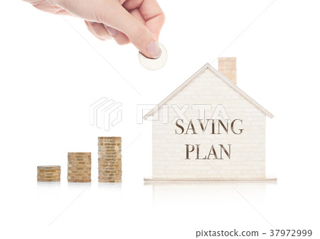 Wooden house model with coins next to it and hand 37972999
