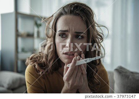 Desperate young woman holding pregnancy test Desperate young woman holding pregnancy test 37973147