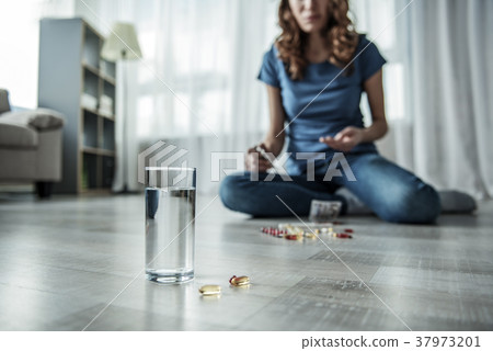 Young woman committing suicide by drugs Young woman committing suicide by drugs 37973201