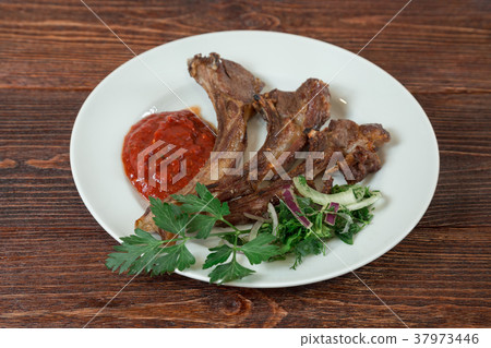 Roasted lamb ribs on a plate. Roasted lamb ribs on a plate. 37973446