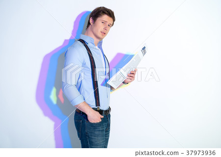 Assertive man looking through newspaper 37973936