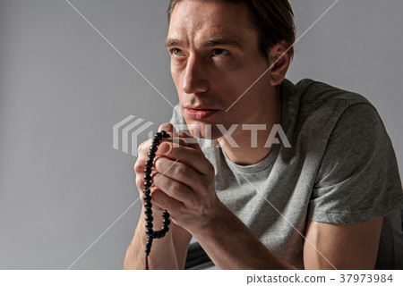 Serene male person being at his devotions 37973984
