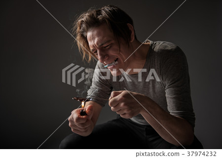Desirous guy fusing narcotic in spoon Desirous guy fusing narcotic in spoon 37974232