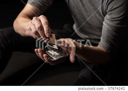 Hands of junkie readying dose of cocaine Hands of junkie readying dose of cocaine 37974242
