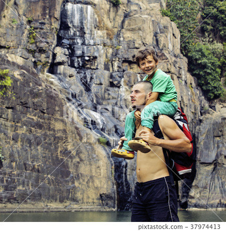 father and son making a trip to waterfall together 37974413