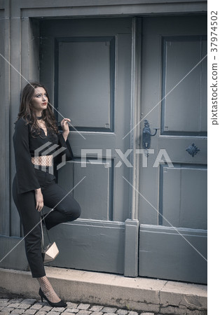 Woman in elegant black clothes looking up 37974502