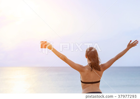Woman drinking coffee in red cup and relax on the tropical beach in morning time. With space for text or design Woman drinking coffee in red cup and relax on the tropical beach in morning time. With space for text or design 37977293