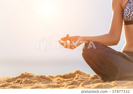 Woman playing Yoga and exercise on the tropical beach in sunset time. With space for text or design 37977332