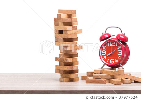 Pile of blocks wood game and red alarm clock on wooden table. Studio shot and isolated on white Pile of blocks wood game and red alarm clock on wooden table. Studio shot and isolated on white 37977524