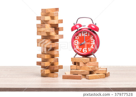 Pile of blocks wood game and red alarm clock on wooden table. Studio shot and isolated on white Pile of blocks wood game and red alarm clock on wooden table. Studio shot and isolated on white 37977528