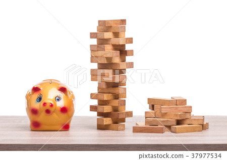 Pile of blocks wood game and piggy bank on wooden table. Studio shot and isolated on white Pile of blocks wood game and piggy bank on wooden table. Studio shot and isolated on white 37977534