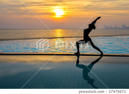 Silhouette young woman practicing yoga Silhouette young woman practicing yoga 37979872