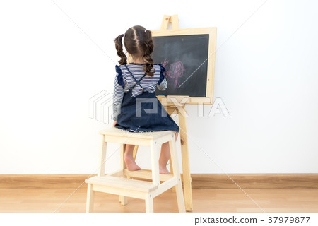 Cute little girl drawing on chalkboard at home 37979877
