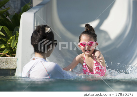 Parent and child playing in the pool 37980172