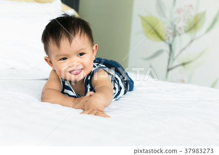 Adorable baby boy smiling on bedroom. 37983273