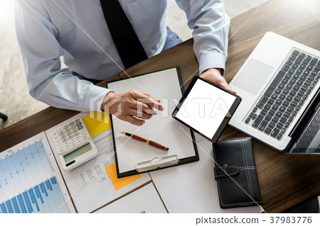 Business man working at office with laptop, tablet and graph dat Business man working at office with laptop, tablet and graph dat 37983776