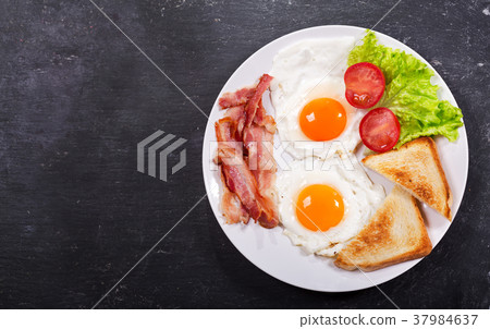 plate of fried eggs with bacon and vegetables plate of fried eggs with bacon and vegetables 37984637