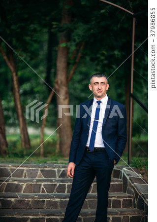 The groom in wedding day in a dark suit, sunny day 37986855