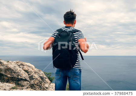 male traveler with a backpack on her back looking male traveler with a backpack on her back looking 37988475