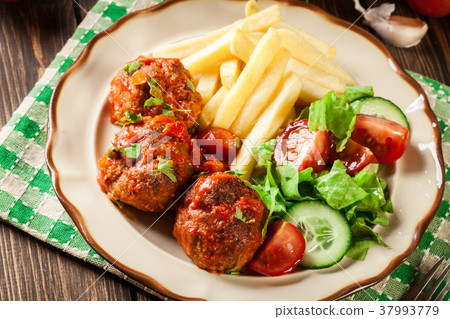 Roasted meatballs in tomato sauce with fries Roasted meatballs in tomato sauce with fries 37993779