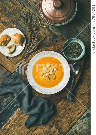 Warming pumpkin cream soup with croutons and seeds Warming pumpkin cream soup with croutons and seeds 37994291
