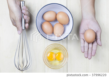 Hand man Asian holding egg and whisk with egg 37996220