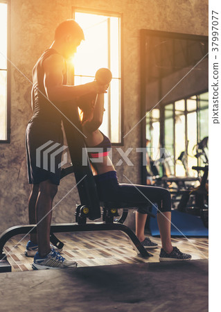 Portrait pretty girl training in gym with trainer 37997077