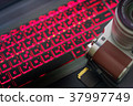 Mirrorless camera and lens against red glow keyboa 37997749