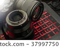 Mirrorless camera and lens against red glow keyboa 37997750